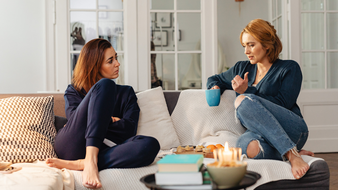 Two female friends chatting on the couch